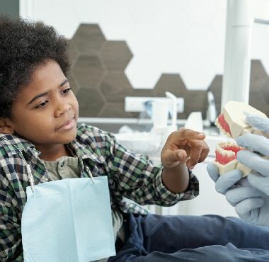 Httpselements.envato.comadorable african boy pointing at false teeth held B5YTAYP.jpg
